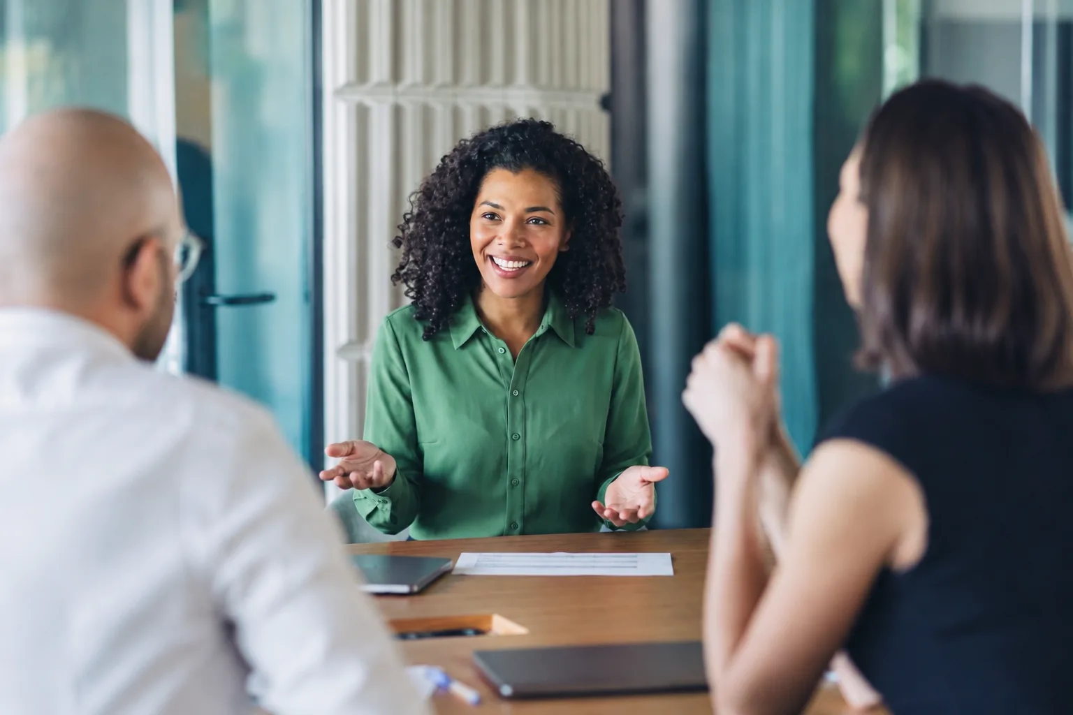 A researcher discussing findings with academic partners around a table.